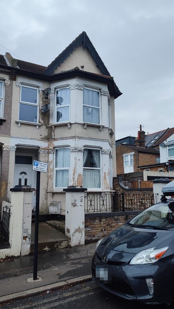 End-of-terrace house before exterior refurbishment, with peeling paint and worn render